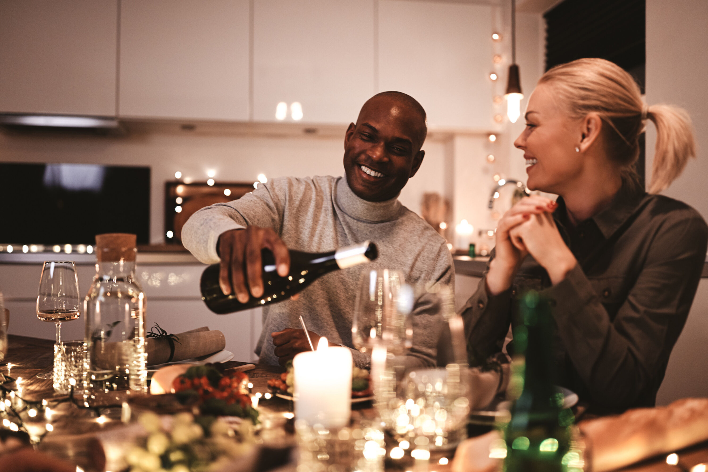 Zwei Personen beim Candle Light Dinner mit Wein und Kerzen
