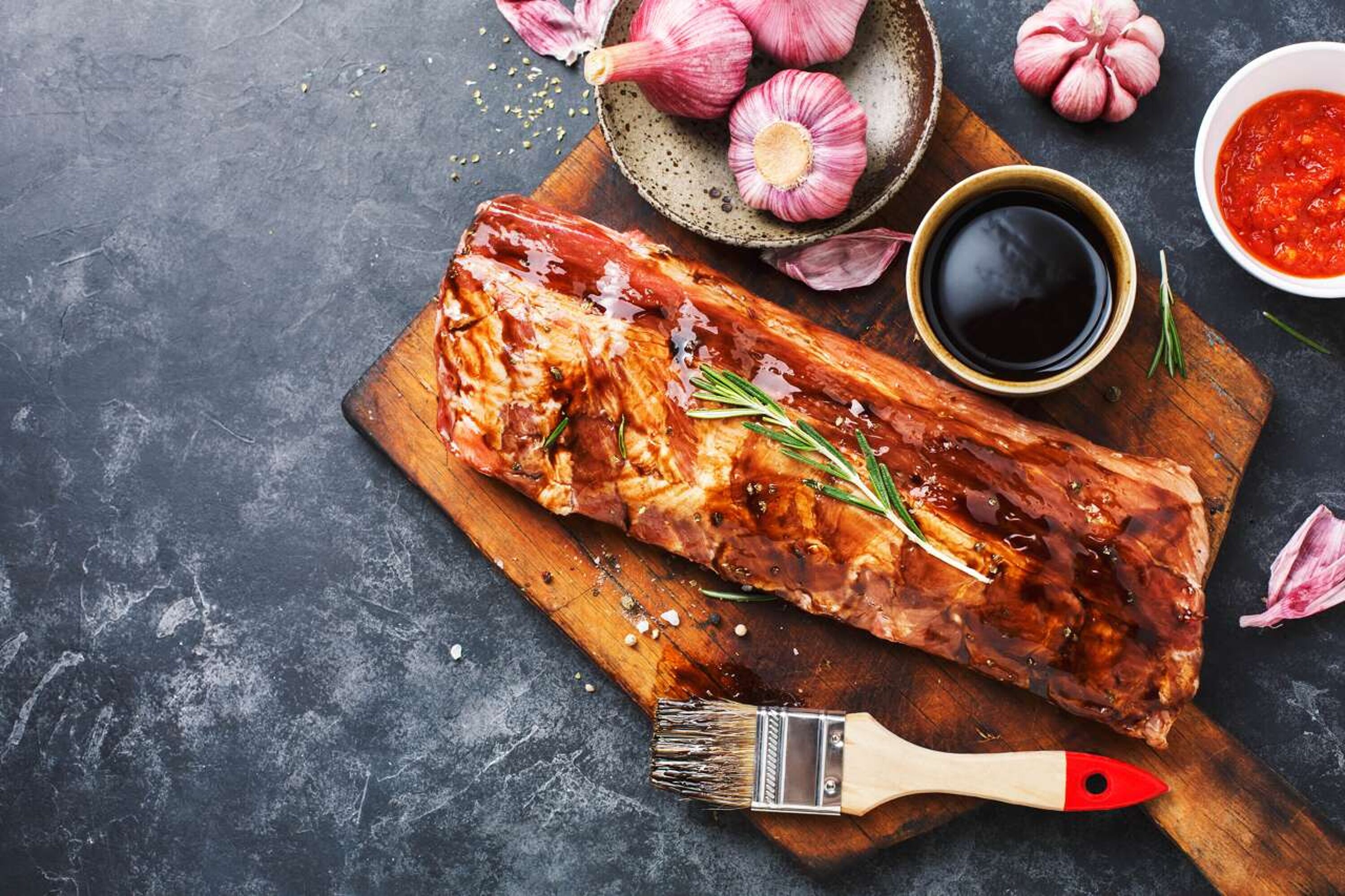 Mariniertes Stück Fleisch mit Knoblauch und Saucen